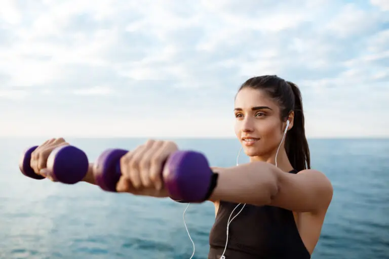 Woman exercising at sunrise by the sea as part of her exercise for clear skin routine