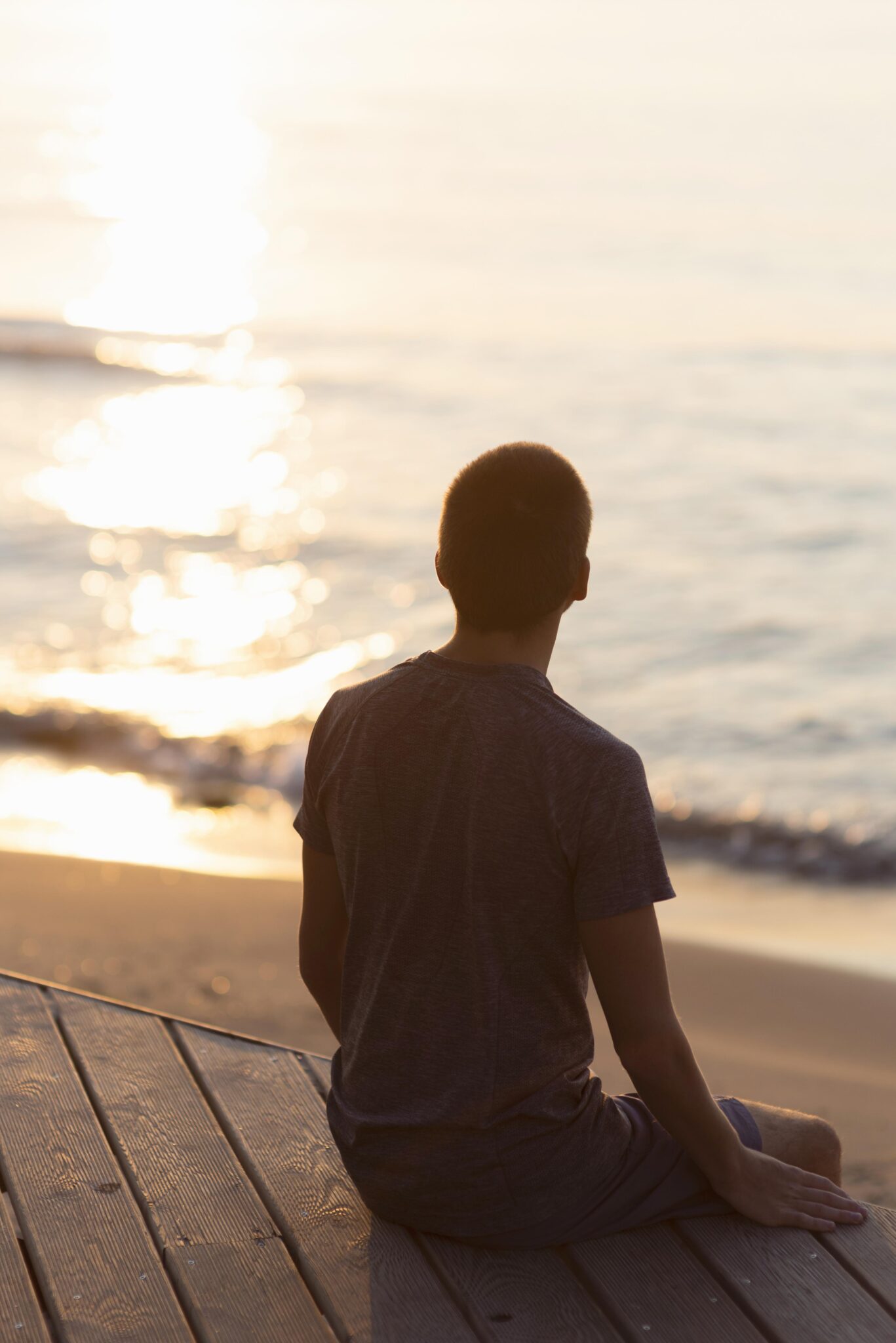 Man meditating on the beach representing the 8 dimensions of wellness