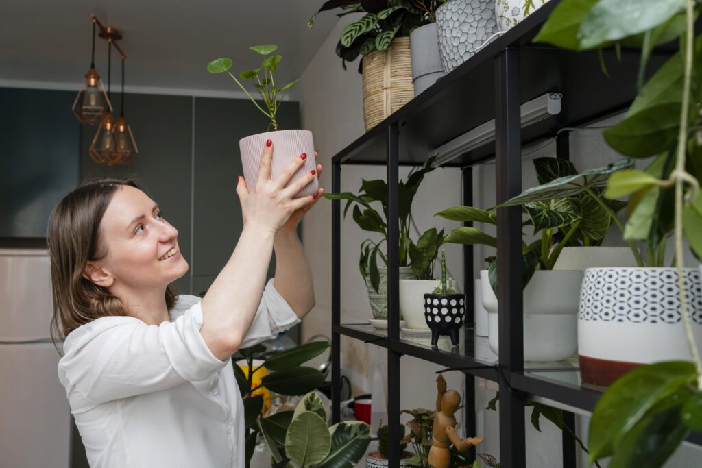 Woman practicing sustainable gardening by tending to her plants at home