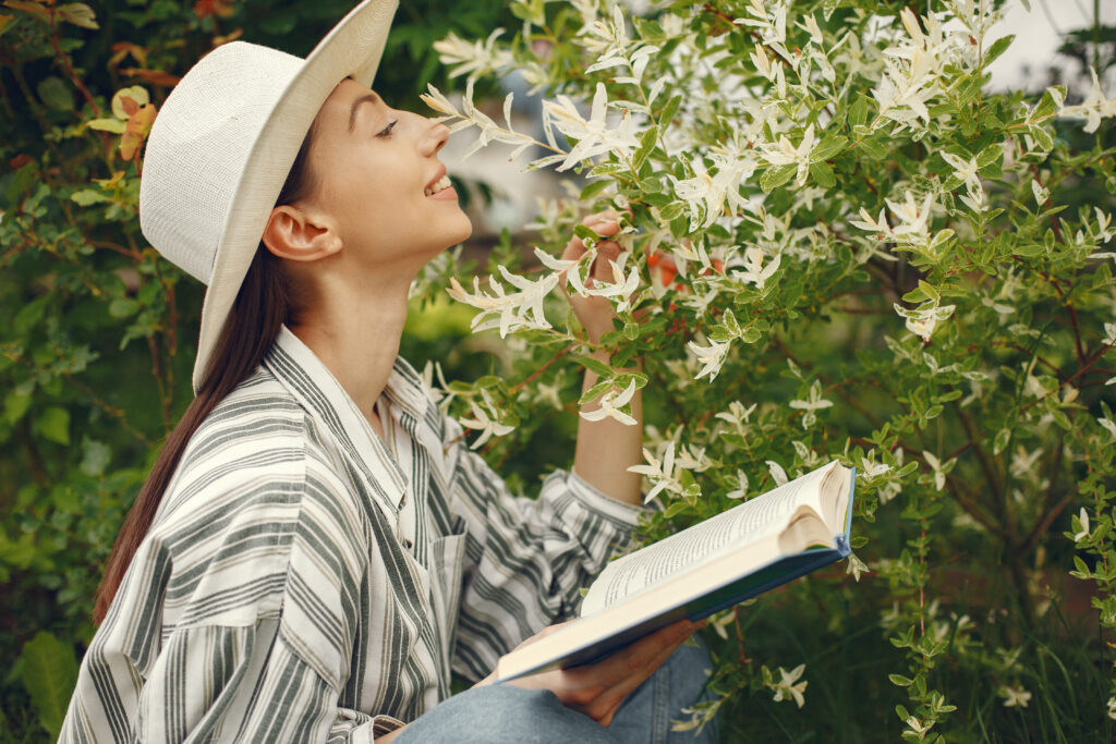 Woman relaxing in garden reading a book practicing skin fasting