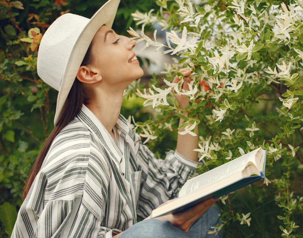 Woman relaxing in garden reading a book practicing skin fasting