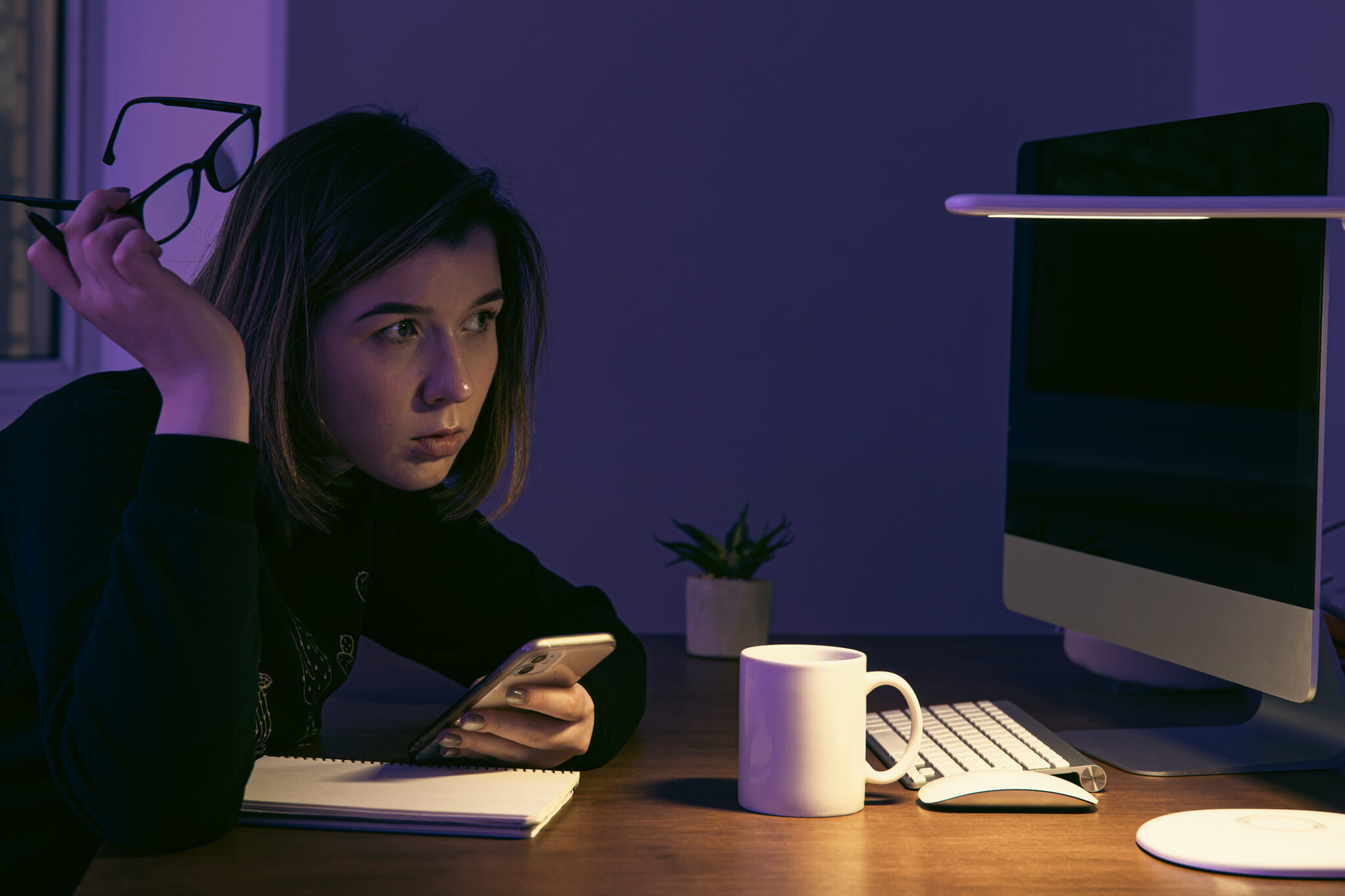 Woman working late at night, emphasizing the need for blue light skin protection