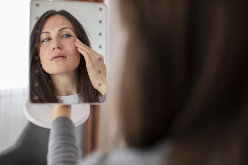Close-up of woman examining her face practicing skin fasting