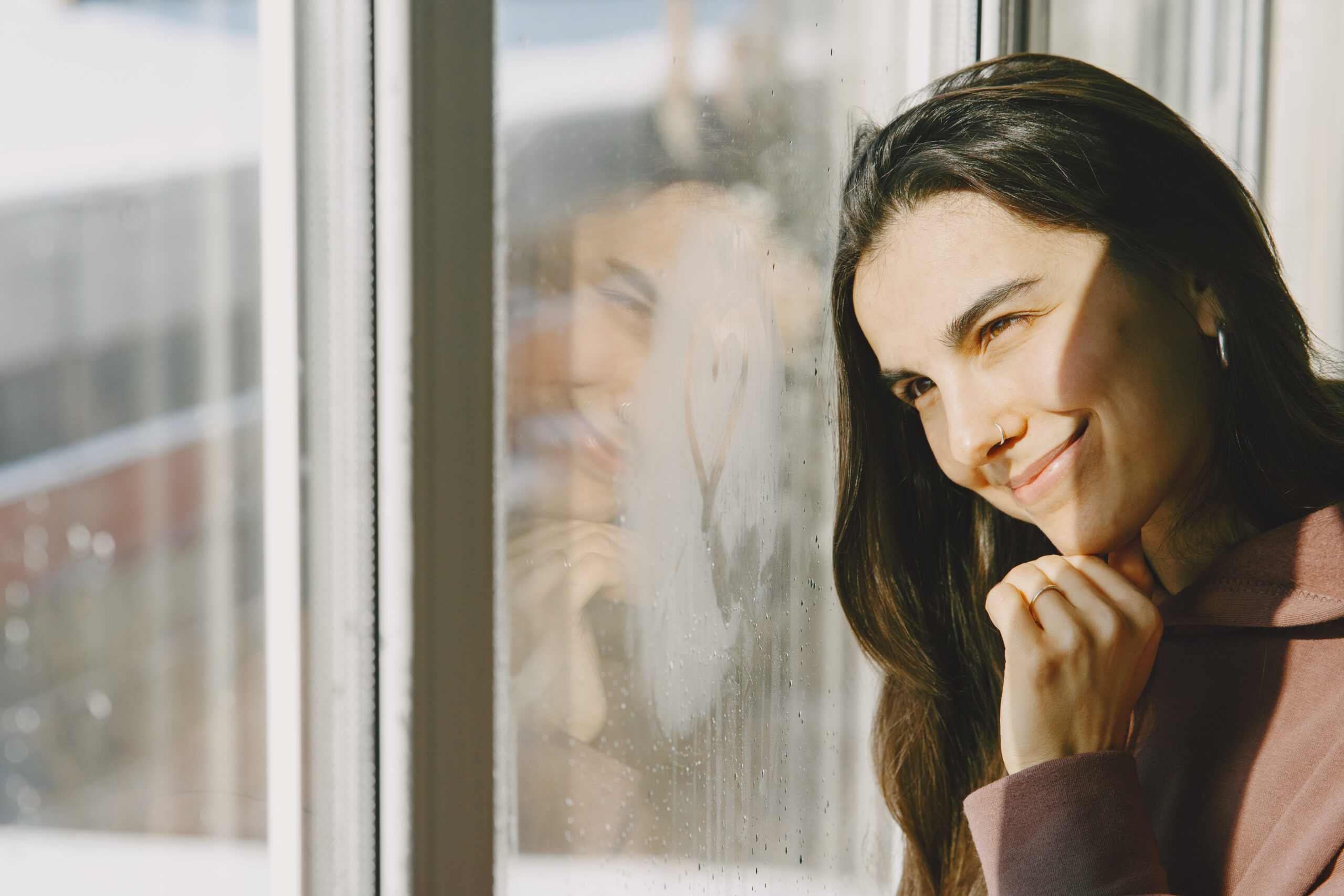 Woman enjoying sunlight indoors during skin fasting period